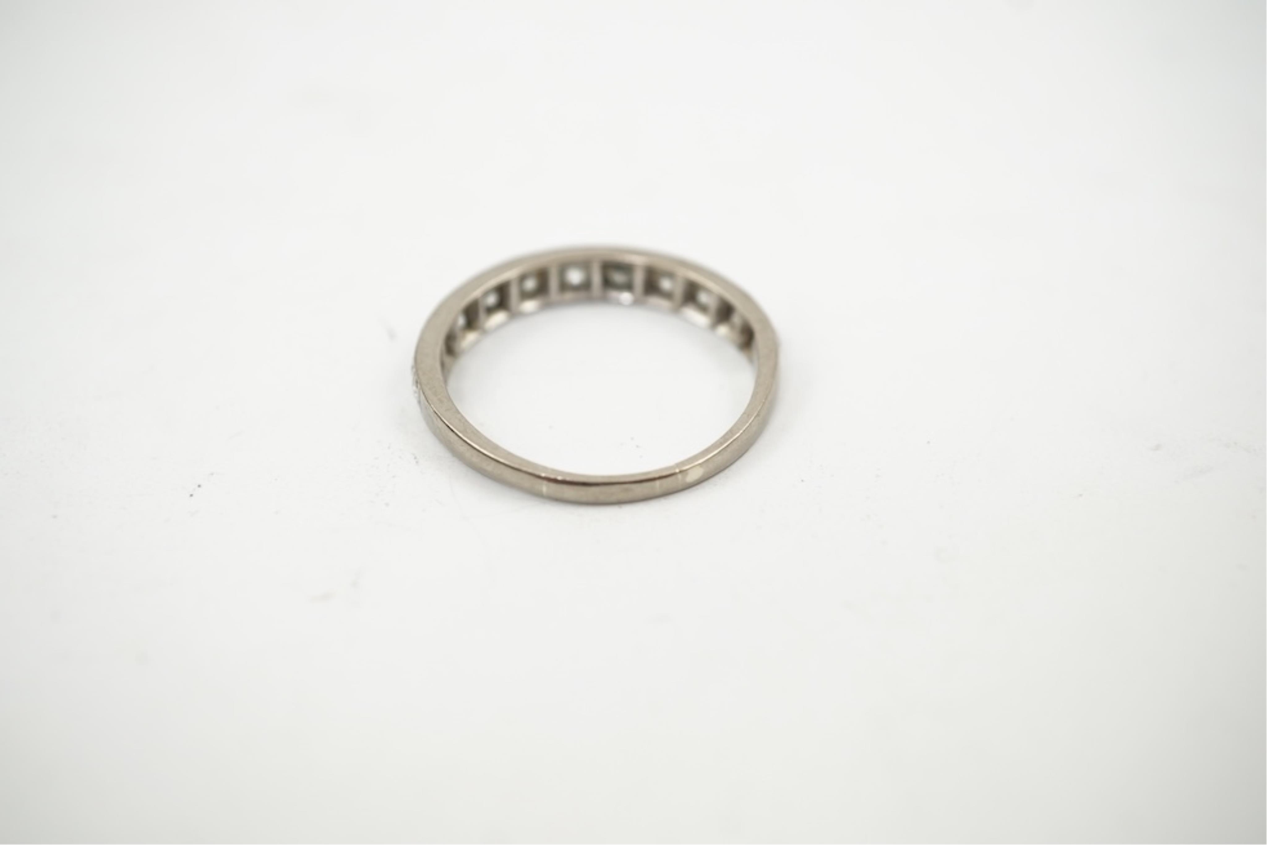 An 18ct white metal and graduated eleven stone diamond set half eternity ring, size P/Q. gross weight 3 grams.